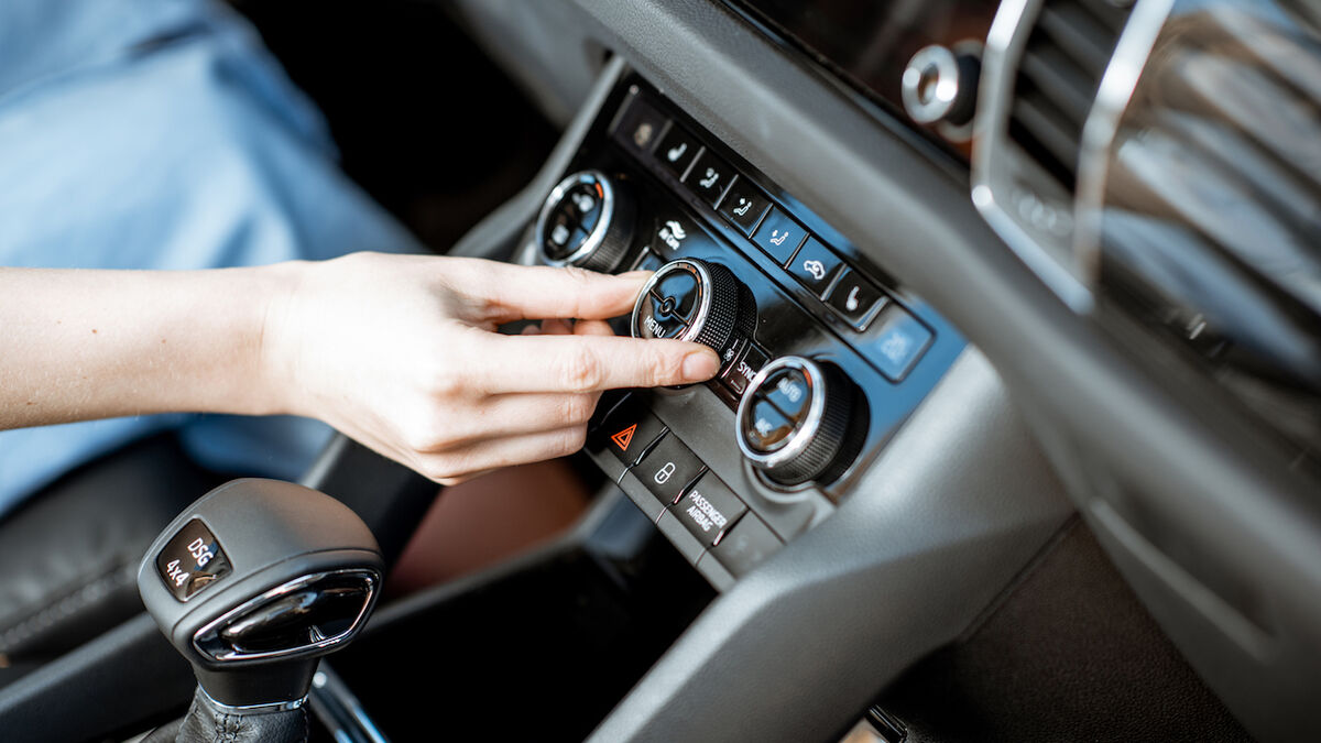 Técnico revisando el sistema de aire acondicionado de un auto